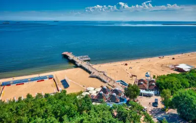 Molo w Brzeźnie, plaża i budynki z zielenią tworzą piękne gdańsk brzeźno atrakcje.