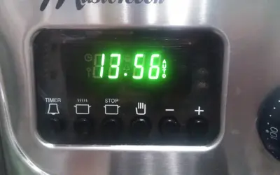 Cyfrowy wyświetlacz piekarnika Mastercook pokazuje godzinę 13:56. Ikony sugerują funkcje timera, gotowania, stopu i automatycznego trybu.