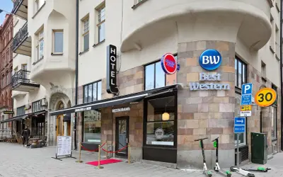 Best Western hotel vid 108, med restaurang Burgers & Beer och en taco bar. Elsparkcyklar står parkerade utanför.