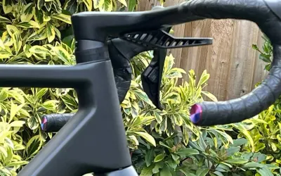 Czarne, aerodynamiczne kierownica z owijką i uchwytem na bidon. Mostek w rowerze jest integralną częścią tej sportowej maszyny.