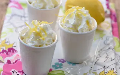 Délicieuse mousse ricotta citron, garnie de zestes frais et servie dans de petits ramequins blancs. Un dessert léger et rafraîchissant.