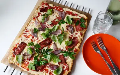 En läcker pizza med bacon och lök, toppad med färska örter och smält ost. Perfekt för en snabb och smakrik måltid.