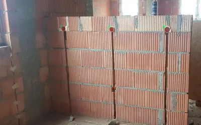 Bruzdowanie pod kable cena. Ściana z pustaków ceramicznych z wyciętymi bruzdami i puszkami instalacyjnymi.
