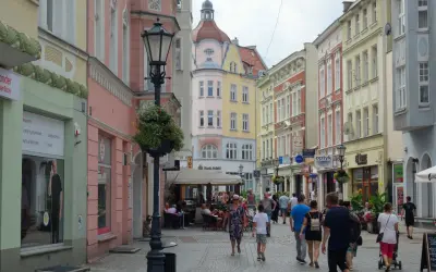 Spacer po urokliwej uliczce z kolorowymi kamienicami, idealne miejsce na zielona góra atrakcje na weekend. Ludzie spacerują, siedzą w kawiarniach.