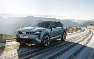 Nowy Dacia c neo STRIKER przemierza krętą, ośnieżoną drogę w górach.