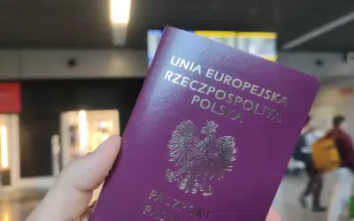 Polski paszport w dłoni, gotowy do podróży. Może to być początek drogi po wizę do Anglii.