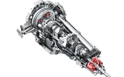 Przekładnia s tronic z widocznymi czerwonymi elementami, ukazująca skomplikowany mechanizm kół zębatych i wałów.