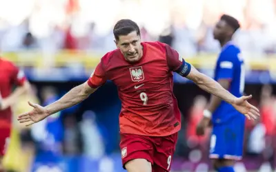 Robert Lewandowski cieszy się po strzelonym karnym. Piłkarz w czerwonej koszulce z numerem 9 świętuje zwycięstwo.
