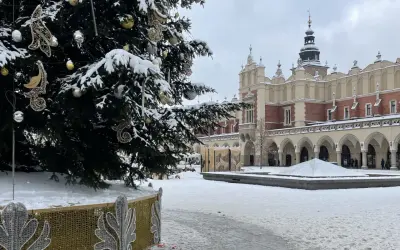 Świąteczna choinka na Rynku Głównym w Krakowie, otoczona śniegiem. To jedna z głównych kraków atrakcje zimą.