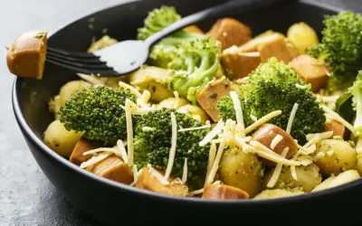 Ein schnelles Gericht mit Kartoffeln, Brokkoli und Würstchen, bestreut mit Käse. Perfekt für Rezepte mit wenig Zutaten.
