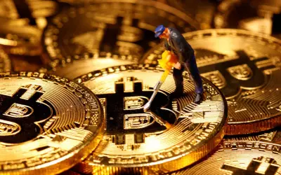 Figurka górnika z kilofem na złotych monetach Bitcoin. Cena kryptowaluty zależy od wielu czynników, w tym od popytu i podaży.
