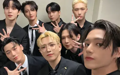 Grupa ATEEZ w czarnych garniturach, gotowa do promocji nowych **ateez albumy**.