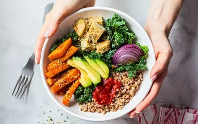 Zdrowy bowl z kaszą gryczaną, pieczonymi batatami, awokado, tofu, jarmużem i czerwoną cebulą.