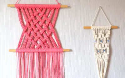 Deux tentures murales en macramé : une rose vif avec un motif croisé, et une écru avec des perles bleues. Idéal pour un tuto macramé mural.