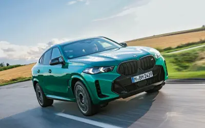 Zielony BMW X6 M Competition, jakby wyłaniał się z krajobrazu, niczym **formentor** w drodze na szczyt.