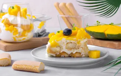 Un délicieux tiramisu mangue, garni de fruits frais et de biscuits à la cuillère. Une touche tropicale pour un dessert rafraîchissant.