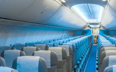 Wnętrze samolotu Boeing 787 LOT. Widok na rzędy pustych siedzeń, które tworzą rozkład miejsc w kabinie pasażerskiej.