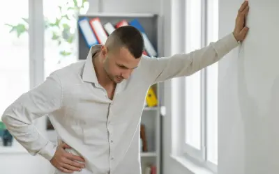 Mężczyzna opiera się o ścianę, czując silną nerwicę i objawy neurologiczne.