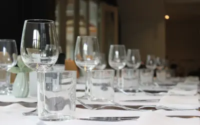 Un élégant placement verre table, prêt pour un repas. Des verres à vin et à eau, des couverts et des serviettes attendent les convives.
