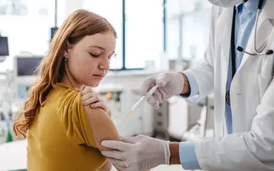 Dziewczynka otrzymuje szczepienie. To ważny krok w zapewnieniu jej zdrowia, podobnie jak fsme immun junior chroni przed kleszczowym zapaleniem mózgu.