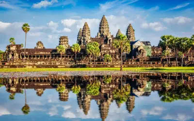Piękna kambodża pogoda nad Angkor Wat. Lotosowy staw odbija majestatyczne wieże świątyni w błękitnym niebie z chmurami.