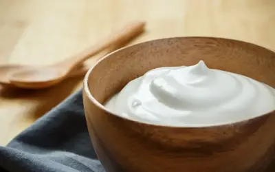 Una ciotola di legno contiene una soffice crema al latte, pronta per essere gustata.