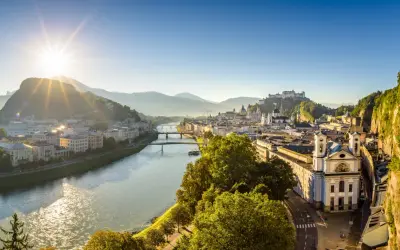 Sonnenaufgang über Salzburg. Die Salzach fließt durch die Stadt, im Hintergrund die Festung Hohensalzburg. Ein perfekter Morgen für smbs salzburg.