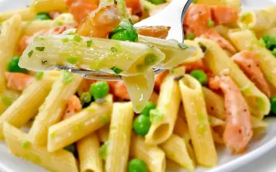 Penne z łososiem wędzonym i groszkiem na widelcu. Pyszne danie, które zachwyci każdego smakosza.