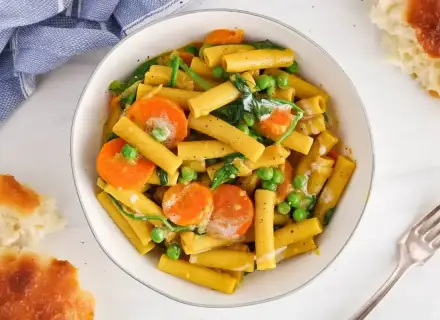Makaron z mlekiem kokosowym i curry, z marchewką i groszkiem. Kremowy sos otula złociste rurki, tworząc aromatyczne danie.