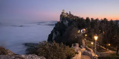 Torre Guaita domina la nebbia al tramonto, un luogo magico dove si trova San Marino.