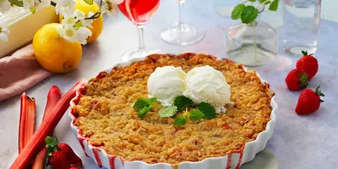 En härlig jordgubbspaj med smuldeg, serverad med vaniljglass och mynta. Perfekt för ett somrigt jordgubbspaj recept.