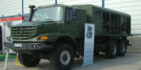 Zielony, terenowy Mercedes Zetros z zabudową, gotowy do pokonywania trudnych dróg.