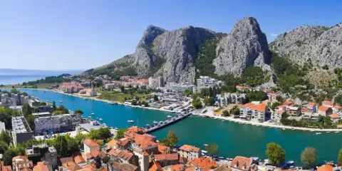 Widok na miasto Omis w Chorwacji z rzeką Cetina i górami w tle.