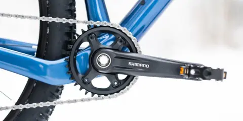 Widok na korbę rowerową Shimano i łańcuch. Dowiedz się, jak odkręcić zapieczone pedały w rowerze, gdy napotkasz takie problemy.