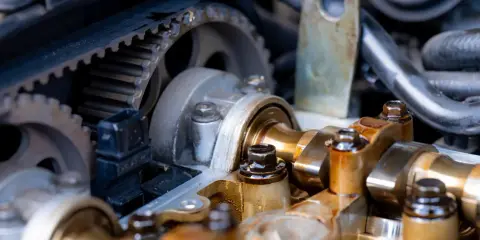 Silnik Opla Astry J 1.4 Turbo. Widoczny rozrząd z paskiem i kołami zębatymi. Wymiana rozrządu po jakim przebiegu jest kluczowa dla żywotności silnika.