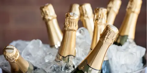 Mehrere Flaschen Prosecco kühlen in einem Eisbad. Perfekt für eine Feier, was ist Prosecco? Ein prickelnder Genuss!