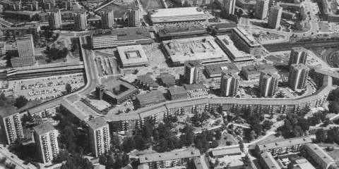 Luftaufnahme einer Siedlung mit vielen Hochhäusern und Wohnblöcken, die die Idee der autogerechten Stadt widerspiegelt.