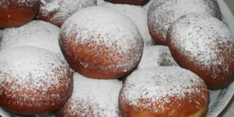 Pyszne, świeżo usmażone paczki posypane cukrem pudrem. Idealne, gdy zastanawiasz się, jak zrobić paczki na tłusty czwartek.