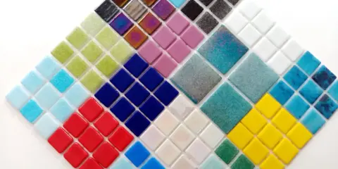 Mosaico de teselas de gresite en forma de rombo, con colores vibrantes como azul, verde, rojo, amarillo y tonos iridiscentes.