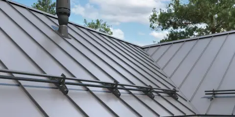 Nowoczesny dach z blachy na rabek, z kominkiem wentylacyjnym i systemem odśnieżania.