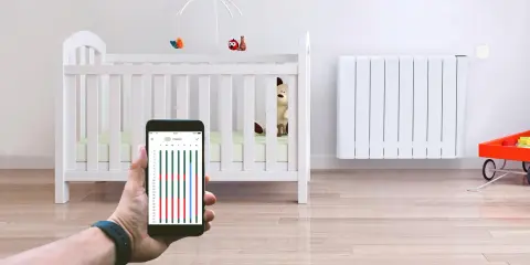 Contrôle du chauffage de la chambre bébé via smartphone. Un radiateur blanc et un lit de bébé sont visibles.