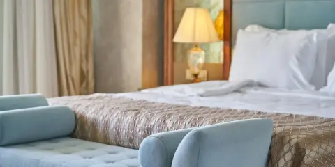 Elegancka sypialnia hotelowa z wygodnym łóżkiem i sofą. Spełnia wszelkie **hotel 4 gwiazdki wymagania** dotyczące komfortu i stylu.
