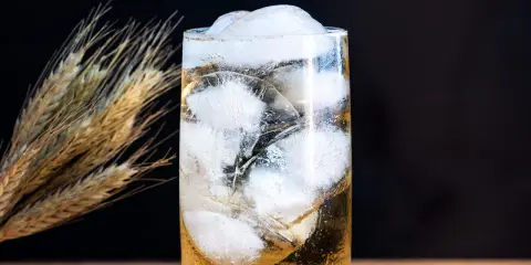 Ein erfrischender Whisky Soda mit viel Eis, daneben ein paar Ähren.