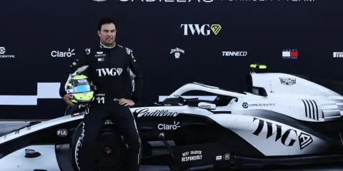 Checo Pérez posa junto a un coche de F1 de Cadillac.