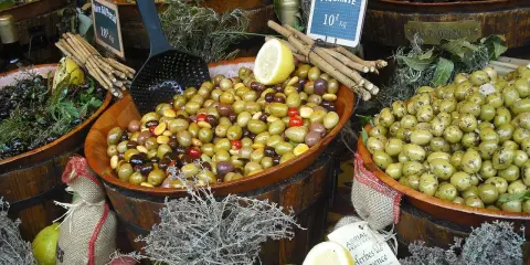 Ambiance de marché à Ansouis : des olives variées, des citrons, de l'ail et des herbes de Provence invitent à la dégustation.