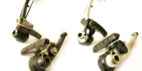 Dwa zestawy hamulców rowerowych V-brake, jeden starszy, drugi nowszy, gotowe do regulacji.