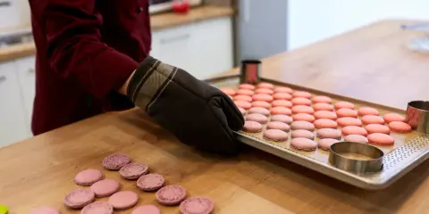Préparation pour la cuisson macaron chaleur tournante : une plaque de macarons roses et roses est sortie du four.