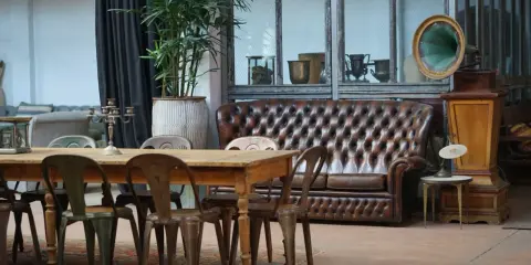Stary gramofon i pikowana kanapa w salonie. Inspiracja, co zrobić ze starymi meblami, by nadać im nowy charakter.