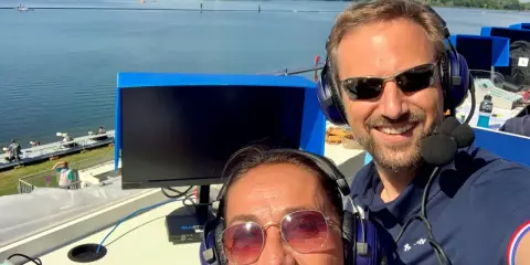 Adrien Hardy et sa collègue commentent une course sur un lac.
