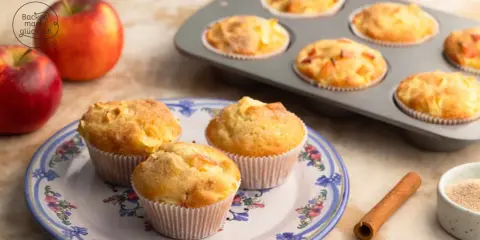 Frisch gebackene Apfelmuffins, die nach einem tollen apfelmuffins rezept duften. Daneben liegen Äpfel und Zimt.
